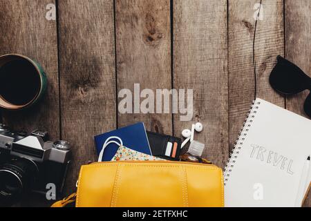 Modello da viaggio piatto con passaporti, portafoglio nero, borsa, maschera protettiva e igienizzatore, blocco note e auricolari, occhiali, tazza di caffè, foto Foto Stock