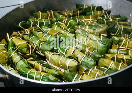 Tamales peruviani avvolti in foglie di banana che cucinano in una pentola. All'interno si trova un impasto a base di mais con carne, che vengono tradizionalmente consumati per la colazione la domenica Foto Stock