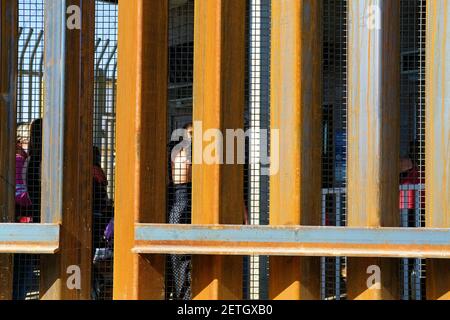 Attraversatori di confine pedonali visti attraverso la recinzione di confine / muro; attraversamento di confine tra Stati Uniti e Messico ad Andrade, California e Los Algodones, Baja California Foto Stock