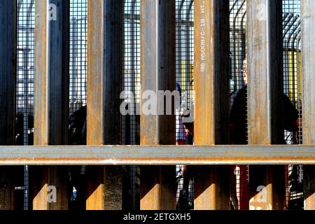 Attraversatori di confine pedonali visti attraverso la recinzione di confine / muro; attraversamento di confine tra Stati Uniti e Messico ad Andrade, California e Los Algodones, Baja California Foto Stock