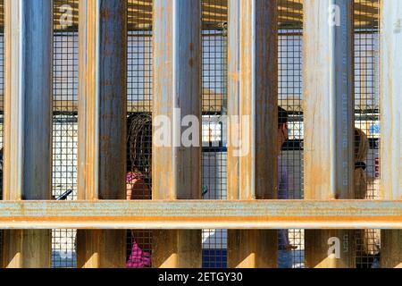 Attraversatori di confine pedonali visti attraverso la recinzione di confine / muro; attraversamento di confine tra Stati Uniti e Messico ad Andrade, California e Los Algodones, Baja California Foto Stock