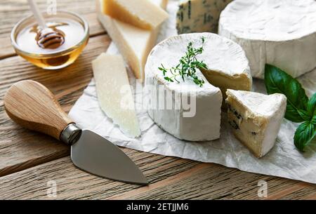 Vari tipi di formaggio, formaggio blu, bree, camambert su un tavolo di legno Foto Stock