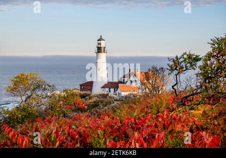 Faro illuminato dal sole che tramonta su un promontorio roccioso Sullo sfondo di un cielo nuvoloso sull'Atlantico Costa a Portland, Maine New Engla Foto Stock