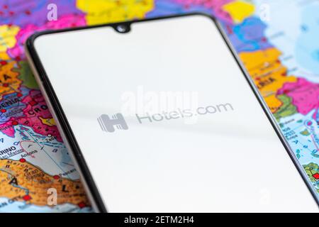 Vilnius, Lituania - 2 marzo 2020: Primo piano dell'app dell'agenzia di viaggi Hotels.com, icone, logo visualizzati su uno smartphone con una mappa geografica Foto Stock