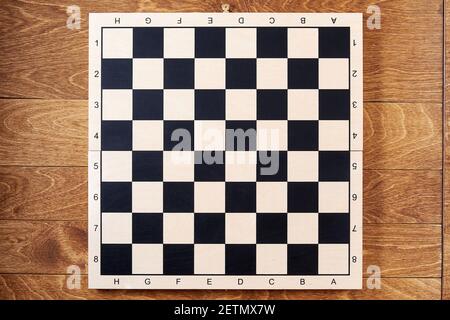 Classica scacchiera vuota sul tavolo di legno marrone. Modello di layout per la strategia e i compiti degli scacchi Foto Stock