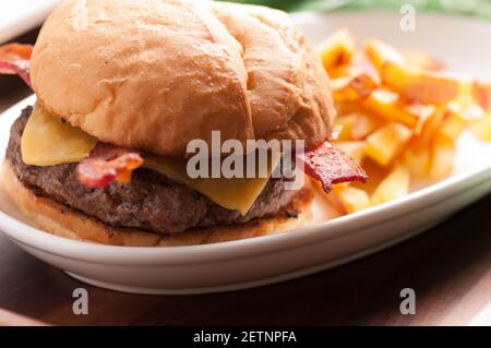 hamburger biologico fresco fattoria con pancetta e formaggio con casa patatine fritte fatte Foto Stock