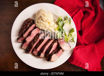 fette rare costolette di manzo occhio bistecca con caesar insalata e. purè di patate Foto Stock