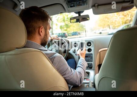 Controllare il telefono cellulare durante la guida invece di prestare attenzione in viaggio Foto Stock