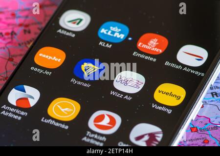 Vilnius, Lituania - 2 marzo 2020: Primo piano di varie compagnie aeree app, icone, logo visualizzato su uno smartphone con una mappa geografica Foto Stock