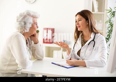 Medico che spiega la diagnosi alla sua paziente femminile in ospedale Foto Stock
