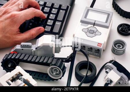 Tambov, Federazione Russa - 25 Dicembre 2019 persona mano sulla tastiera codifica LEGO MINDSTORMS blocchi robot EV3 sul computer. Foto Stock
