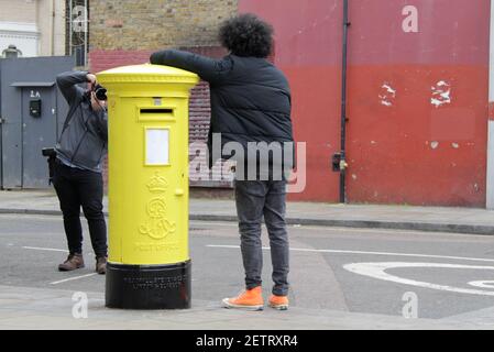 Londra, Regno Unito 2 marzo 2021 - la stampa passa il mouse intorno a Yellow Royal Mail Postbox a West London Foto Stock