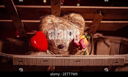 Adorabile orsacchiotto di orsacchiotto fatto a mano un cuore di legno e un rosa sbiadita Foto Stock