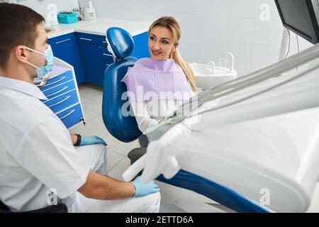 Il dentista è seduto vicino alla sua paziente femminile Foto Stock