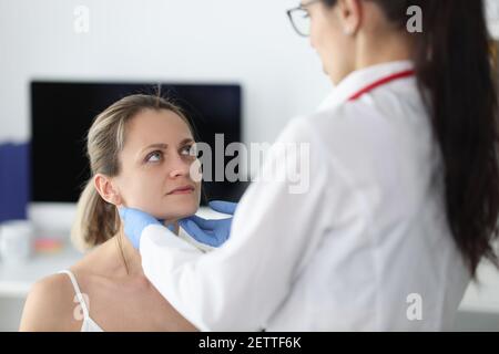 Medico che esamina i pazienti linfonodi submandibolari in clinica Foto Stock