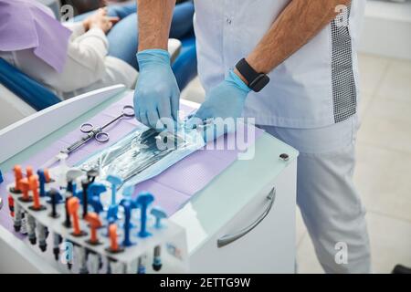 Dentista professionista disimballare gli attrezzi stomatologici dal sacchetto di plastica Foto Stock