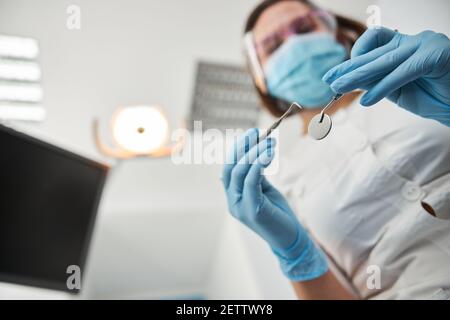 Vista dal basso dei dispositivi dentali nelle mani dei lavoratori medici Foto Stock