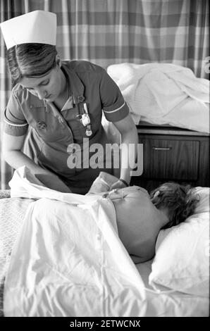 Ospedale Ward Cardiff per bambini. Infermiera che tratta il bambino dopo l'intervento chirurgico Foto Stock