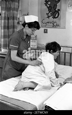 Ospedale Ward Cardiff per bambini. Infermiere trattamento bambino dopo l'intervento chirurgico Foto Stock