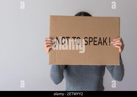 Una donna ha una bandiera con l'iscrizione DI NON PARLARE davanti a lei. Foto Stock