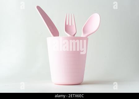 Tazza di plastica, cucchiaio, forchetta e coltello isolati su sfondo bianco Foto Stock