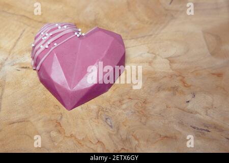 il cuore isolato di cioccolato si trova su una tavola di legno Foto Stock