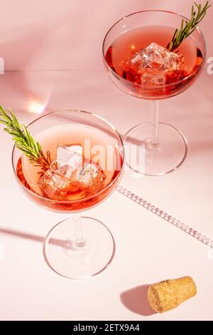 Vista dall'alto di un cocktail rinfrescante con rosmarino in un bicchiere su uno sfondo luminoso. Concetto di festa estiva. Foto Stock