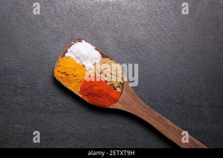 Donna indiana polvere mano spezie indiane rosso freddo, peperoncino paprika polvere esplosione splash utilizzando mortaio di pietra cucina indiana Kerala India Sri Lanka Foto Stock