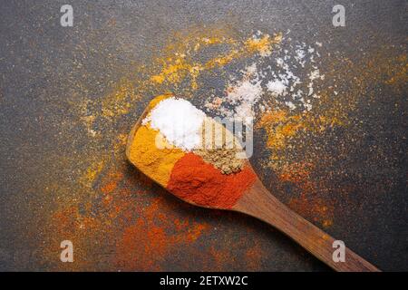 Donna indiana polvere mano spezie indiane rosso freddo, peperoncino paprika polvere esplosione splash utilizzando mortaio di pietra cucina indiana Kerala India Sri Lanka Foto Stock