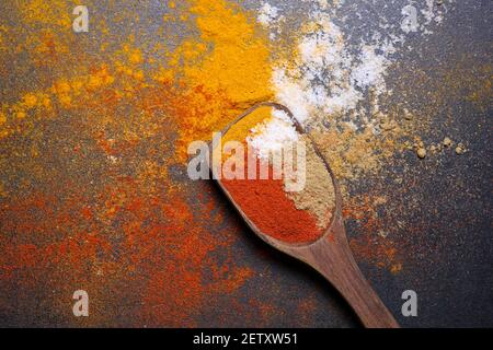 Donna indiana polvere mano spezie indiane rosso freddo, peperoncino paprika polvere esplosione splash utilizzando mortaio di pietra cucina indiana Kerala India Sri Lanka Foto Stock