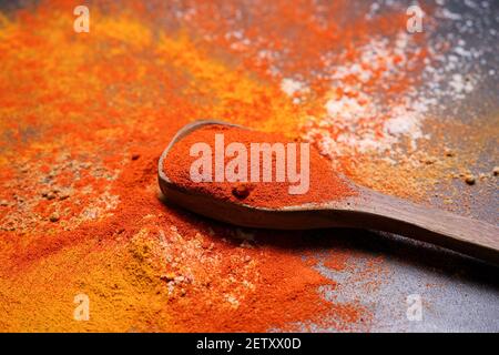 Donna indiana polvere mano spezie indiane rosso freddo, peperoncino paprika polvere esplosione splash utilizzando mortaio di pietra cucina indiana Kerala India Sri Lanka Foto Stock