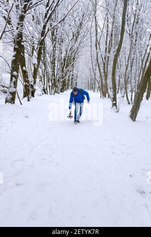 cameraman professionale con fotocamera che scatta riprese nella foresta di neve Foto Stock