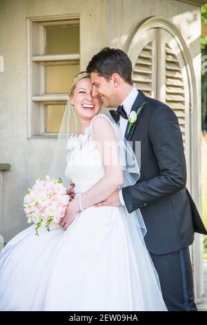 Sposi sposi sposi sposi nuovi nei terreni della casa padronale. Sono in piedi presso una casa d'estate Foto Stock