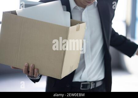 Infornato businessman che trasporta la scatola degli articoli personali Foto Stock