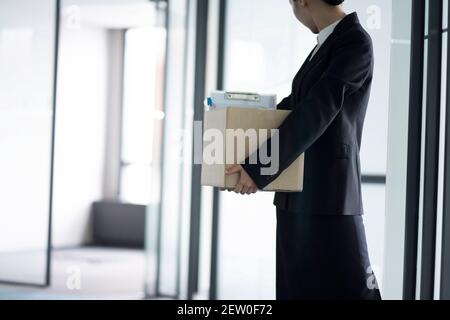 Infornata uomo d'affari che lascia l'ufficio con la scatola di appartiene Foto Stock