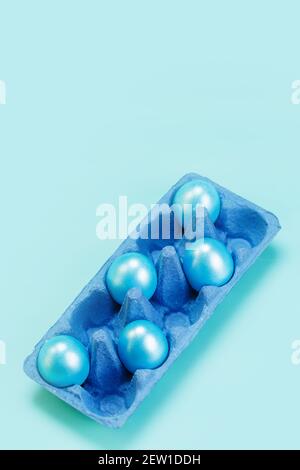 Cinque uova di colore blu perla nel vassoio blu del mercato del cartone, concetto moderno di pasqua alla moda Foto Stock