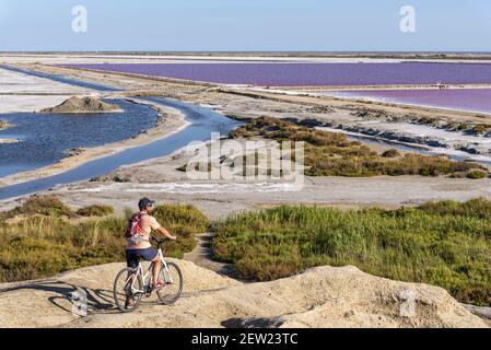 Francia, Bouches du Rhône (13), Viarhôna, Salin de Giraud, ciclista di fronte alle saline Foto Stock