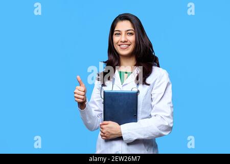 Bella giovane ragazza medica asiatica, con un computer portatile per i record isolato su uno sfondo blu. Medico studente medico medico generico. Il concetto di medic Foto Stock