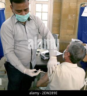 L'operatore sanitario somministra il vaccino Covid-19 al personale paramedico e ai medici durante la campagna di vaccinazione del coronavirus, presso la Khaliq Dina Hall di Karachi martedì 02 marzo 2021. Foto Stock