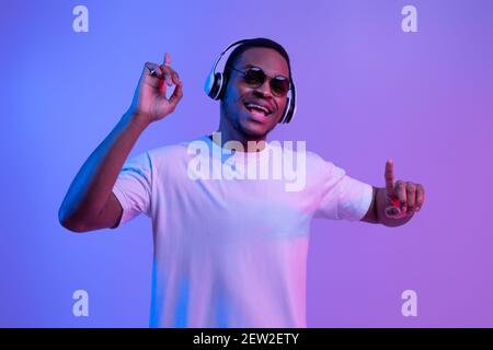 Allegro afroamericano Guy in cuffie wireless ascoltare musica e. Danza Foto Stock