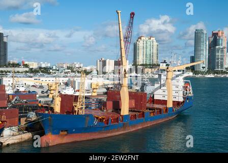 La vista di una nave da carico ormeggiata con gru e lo skyline di Miami Beach sullo sfondo (Florida). Foto Stock