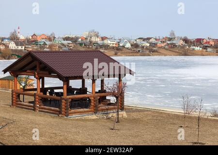 Gazebo in legno sulla riva del fiume in primavera Foto Stock