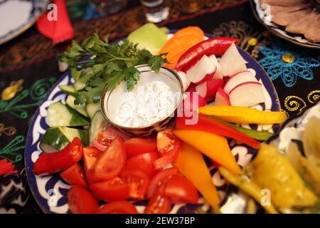 Piatto con varie verdure a fette su una tovaglia ricamata in un ristorante asiatico Foto Stock