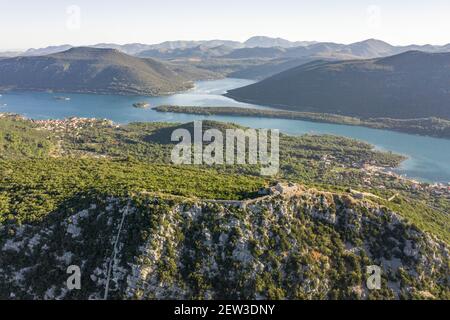 Drone aereo colpo di City Wall di Ston su collina A Mali Ston in Croazia alba estiva Foto Stock