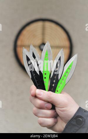 Lancio di coltelli. Sport e hobby . Lancio di coltelli primo piano e un bersaglio sulla parete.Sport all'aperto. Concetto di raggiungimento degli obiettivi. Foto Stock