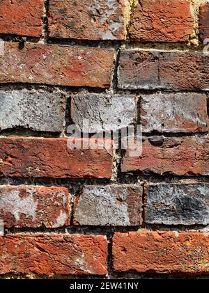 Parte di un muro fatto di mattoni vecchi di forme e colori diversi. Foto Stock