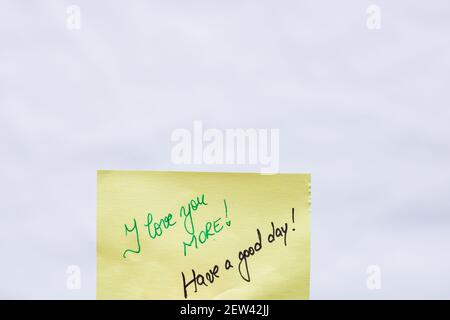Ti amo più handwriting testo primo piano isolato su carta gialla con spazio di copia. Foto Stock