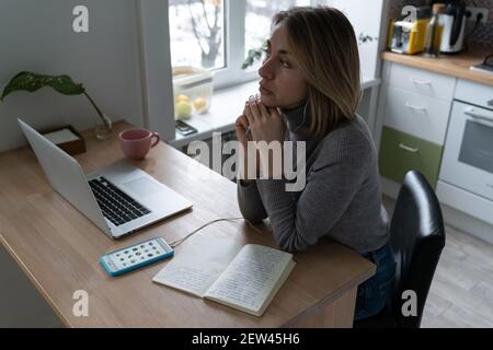 La donna indossa le cuffie, utilizzando lo smartphone, ascolta attentamente un interessante altoparlante in clubhouse. Foto Stock