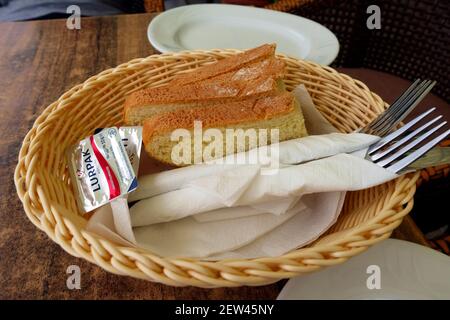 Cestino di pane, burro e posate, tipicamente servito nei ristoranti greci prima dell'arrivo del pasto Foto Stock