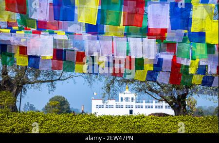 Molte bandiere di preghiera al vento contro il tempio Maya Devi a Lumbini, Nepal. Foto Stock